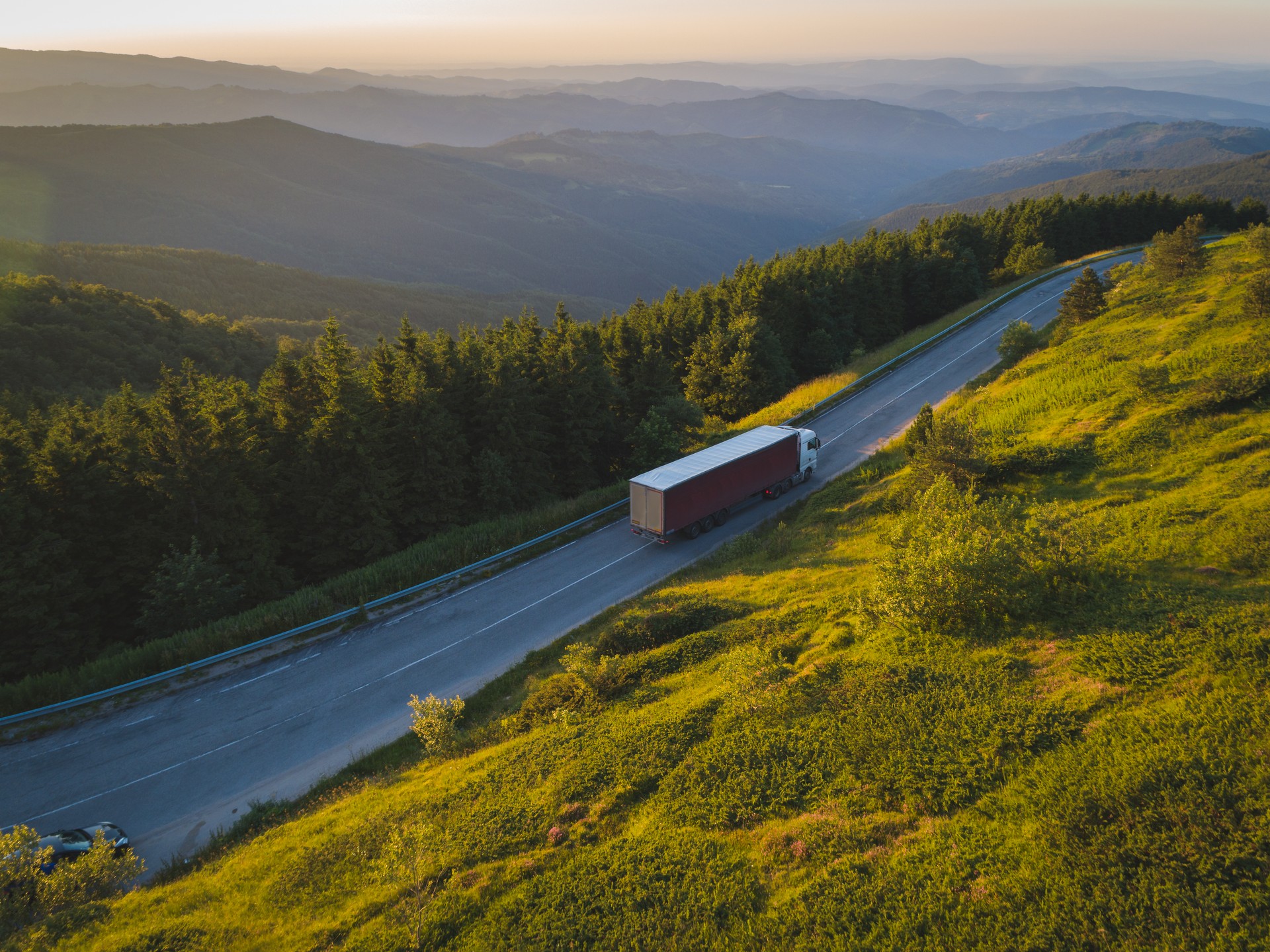 Drone follows  delivery company truck at sunset